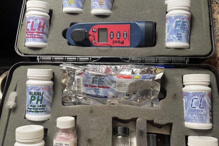 A field water test kit with reagent bottles for pH, chlorine, iron, copper, and alkalinity
